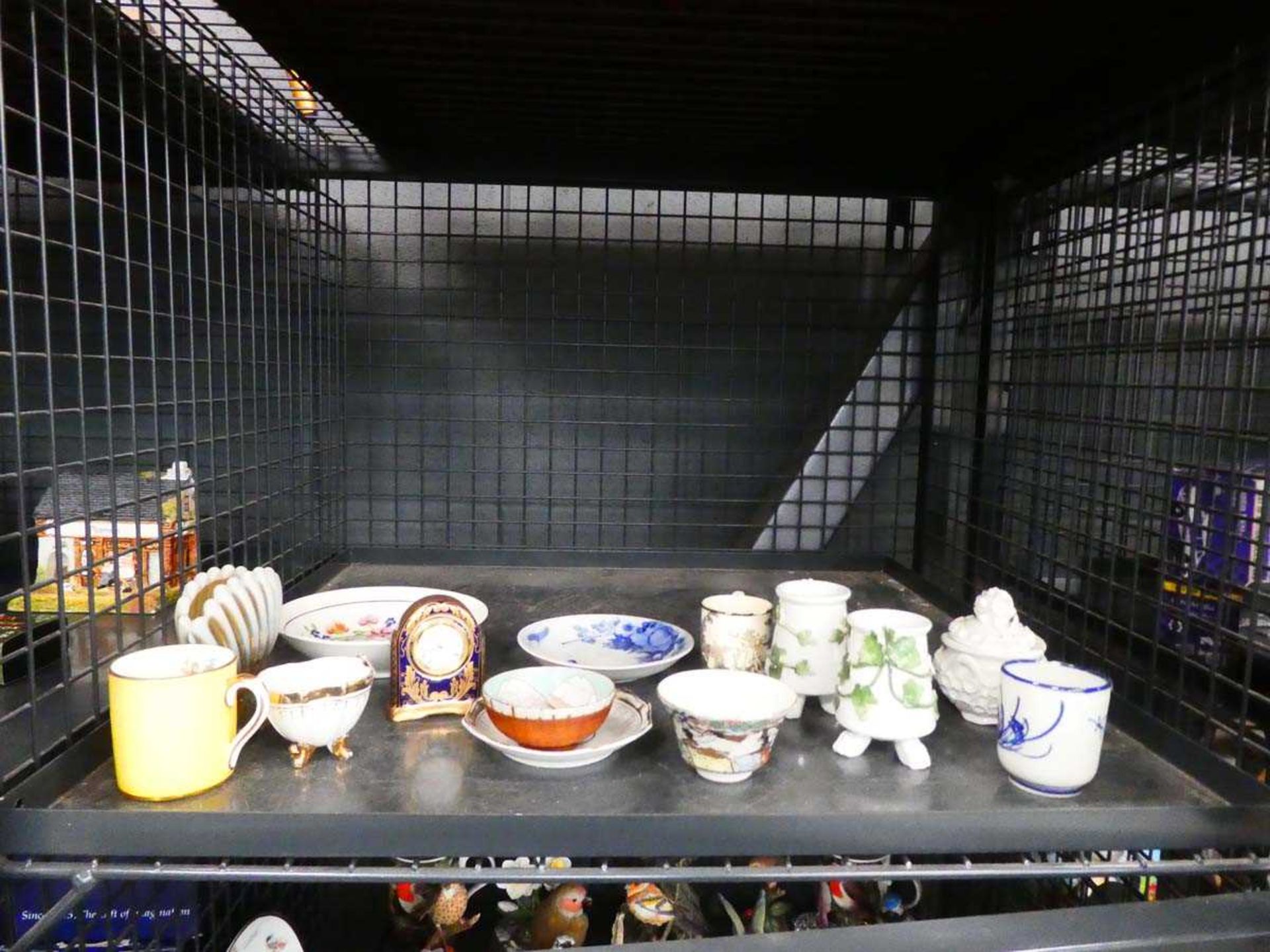 Cage containing a miniature quartz clock plus various bowls and cups