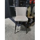 Beige suede upholstered bar stool on black metal support