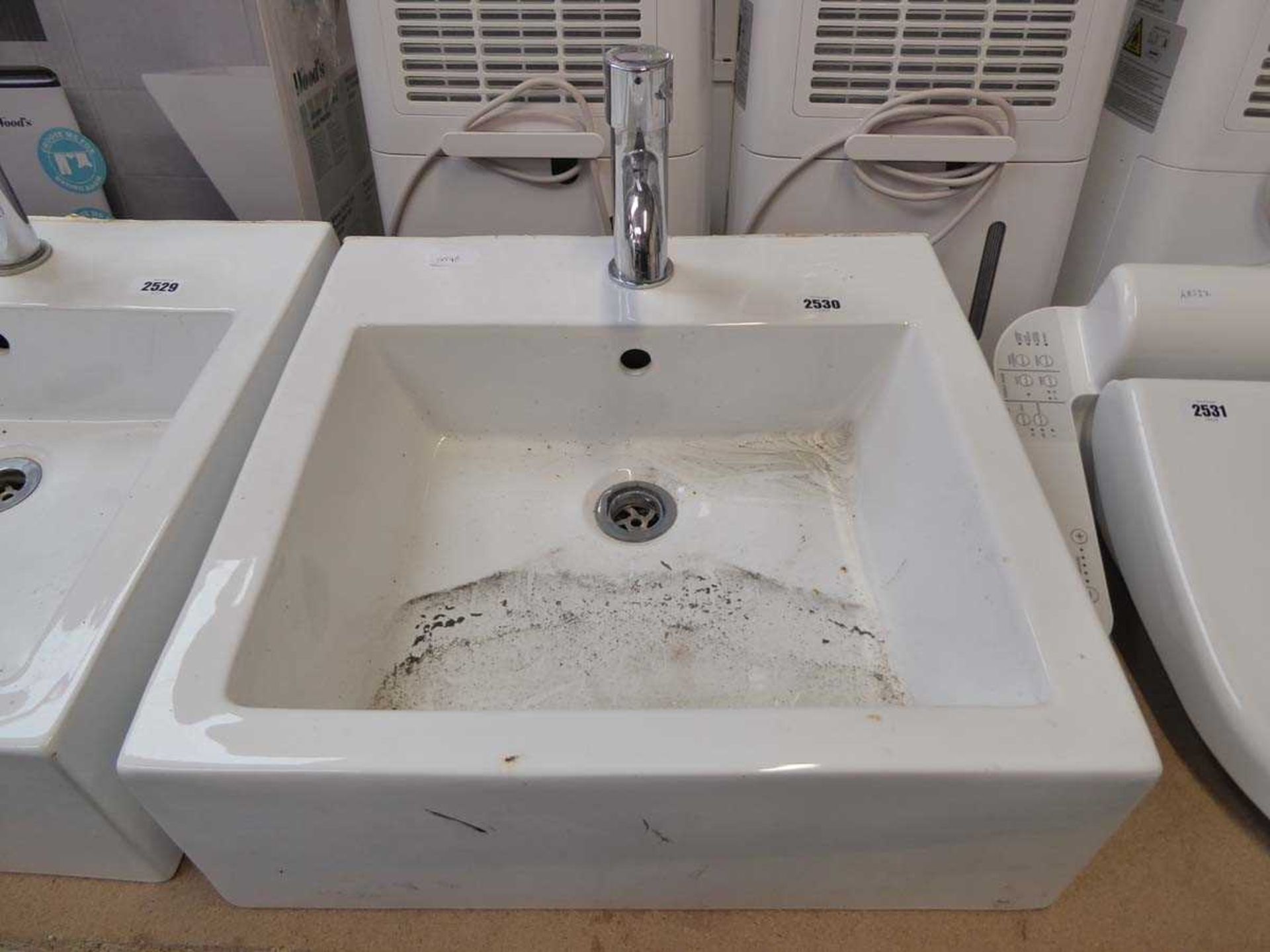 White ceramic square wall mounted basin with chrome tap