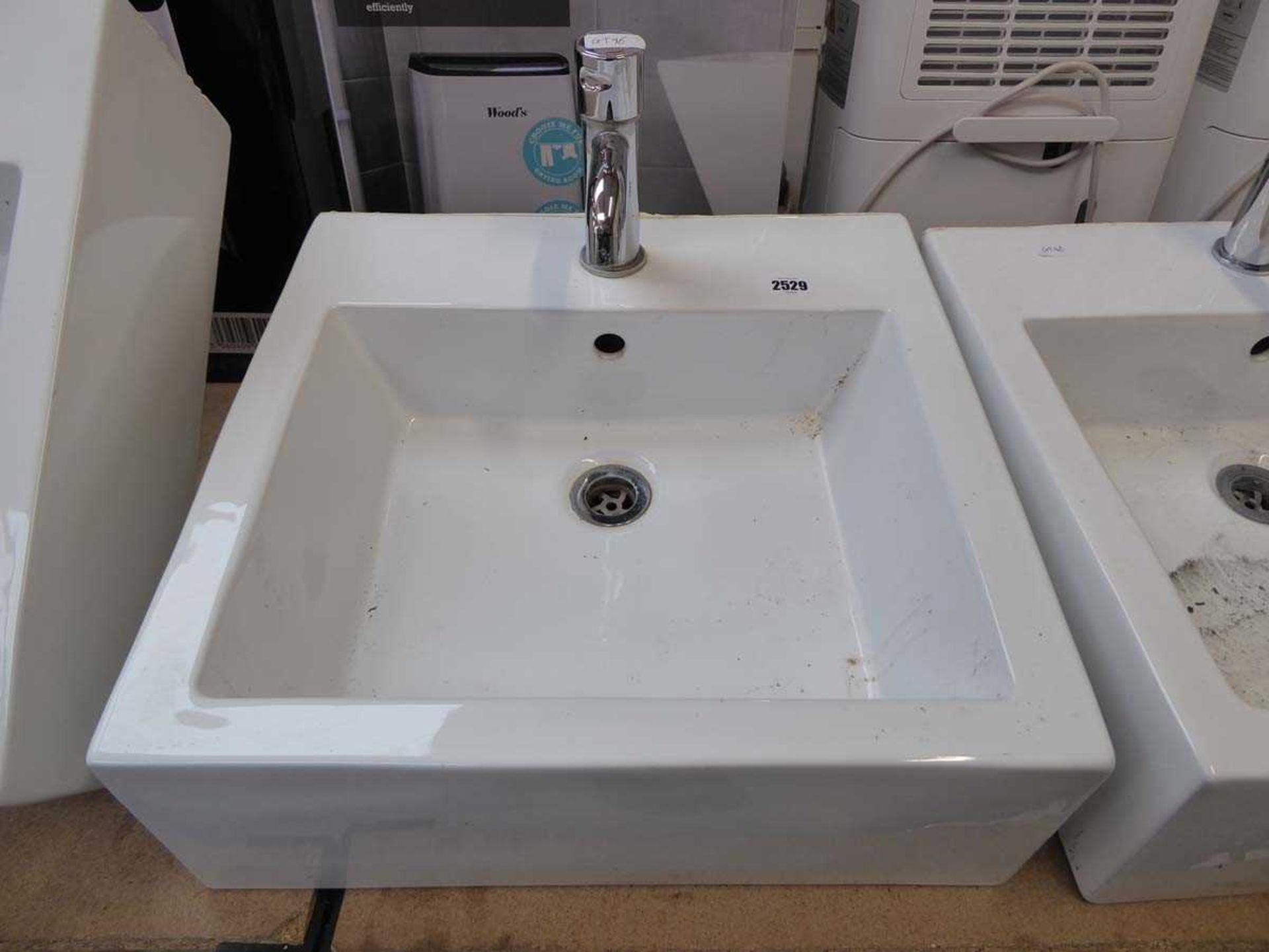 White ceramic square wall mounted basin with chrome tap