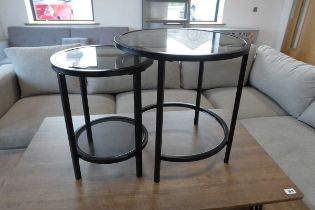 Nesting pair of black finish circular glass top coffee tables