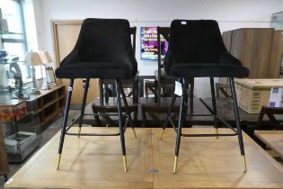 Modern pair of black velvet upholstered bar height stools on black metal supports