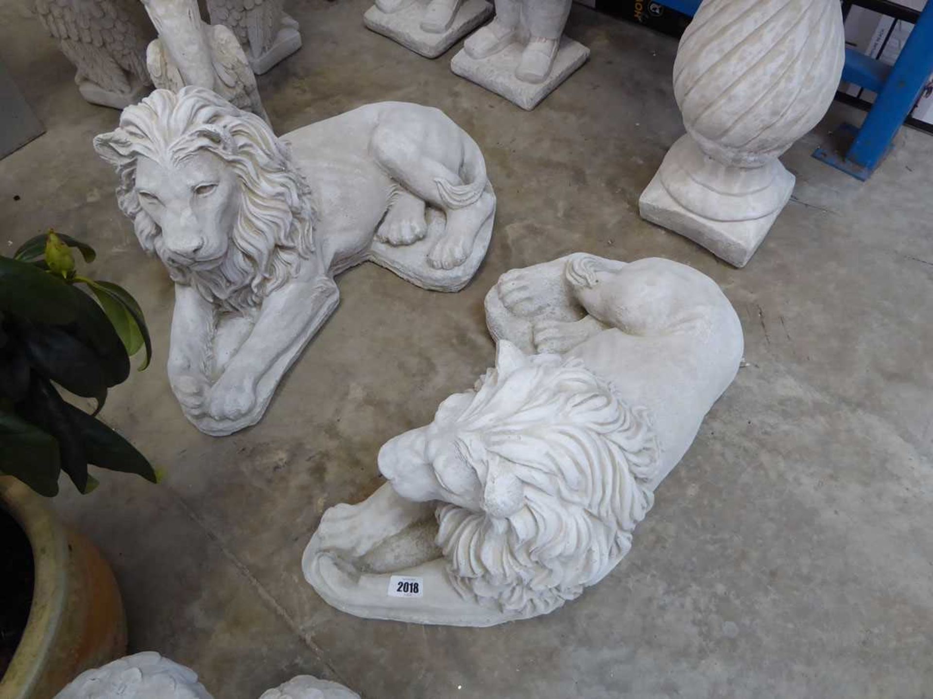 Pair of large laying down concrete lions