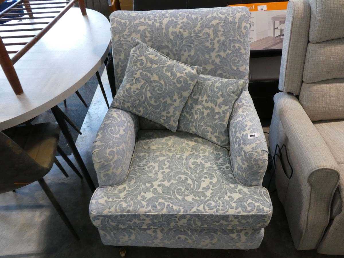 Light blue and beige floral upholstered easy chair on castors