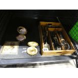 Cage containing various powder compacts, yellow metal jewellery and a tray of white metal cutlery