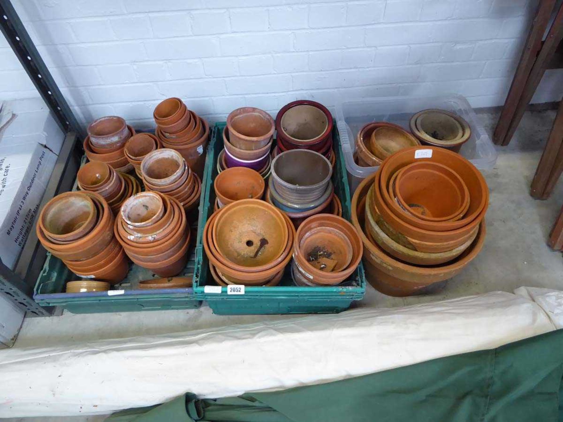 3 crates containing mixed size terracotta garden pots