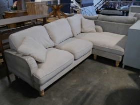 Cream upholstered L-shaped sofa with cushions
