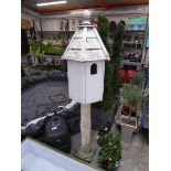 Wooden dove house on concrete pillar