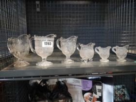 Crate containing various glass jugs