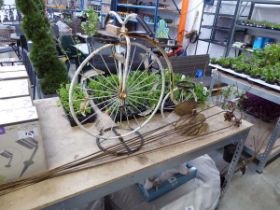 White painted metal ornamental penny farthing pot stand with some metal lily spikes