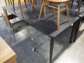 Long black extending dining table on tapered supports