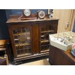 Edwardian oak display cabinet with leaded glass doors and central inlaid motif