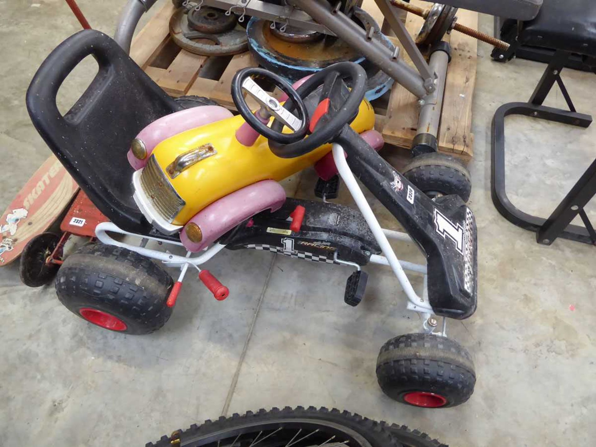 Childs 4 wheeled pedal go kart together with a childs plastic ride on car