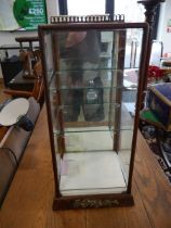 Slender wooden display cabinet with glass interior shelving