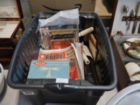 Plastic crate containing various vintage bicycle accessories and magazines
