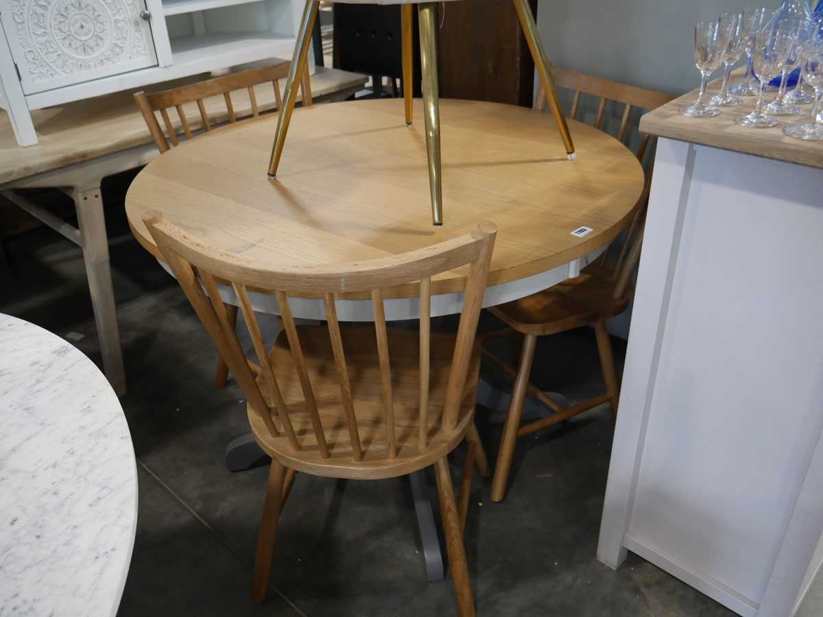 Single pedestal circular dining table with oak effect surface, together with 3 wooden stick back