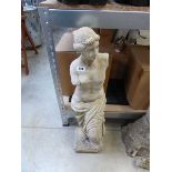 Concrete figurine of armless woman in robe