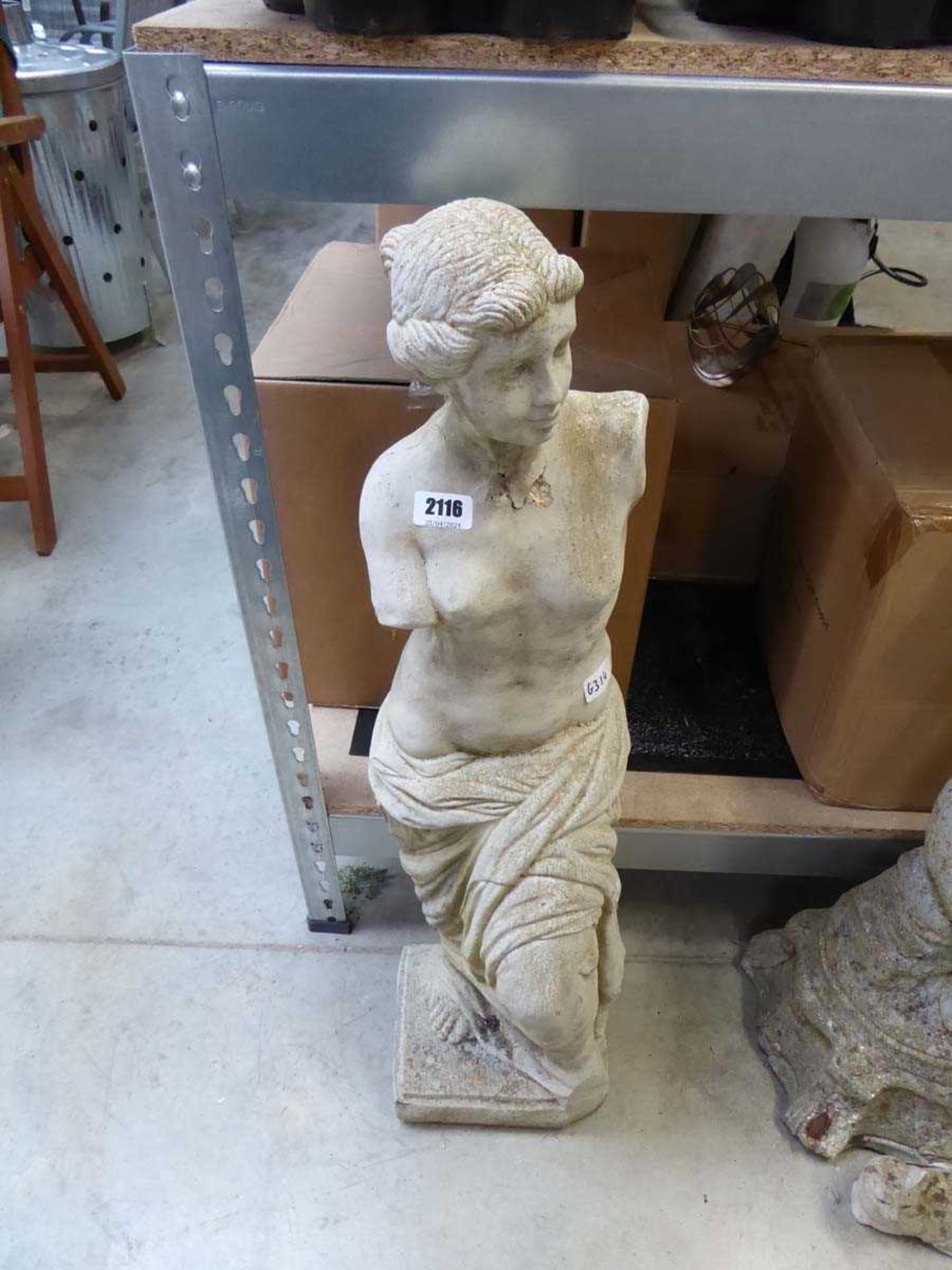 Concrete figurine of armless woman in robe