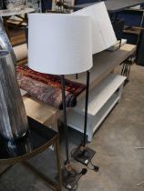 Modern pair of floor standing slender standard lamps with cylindrical cream shade