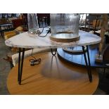 Modern black and white plectrum shaped coffee table on wirework supports