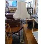 Slender brass standard lantern with cream tasseled shade