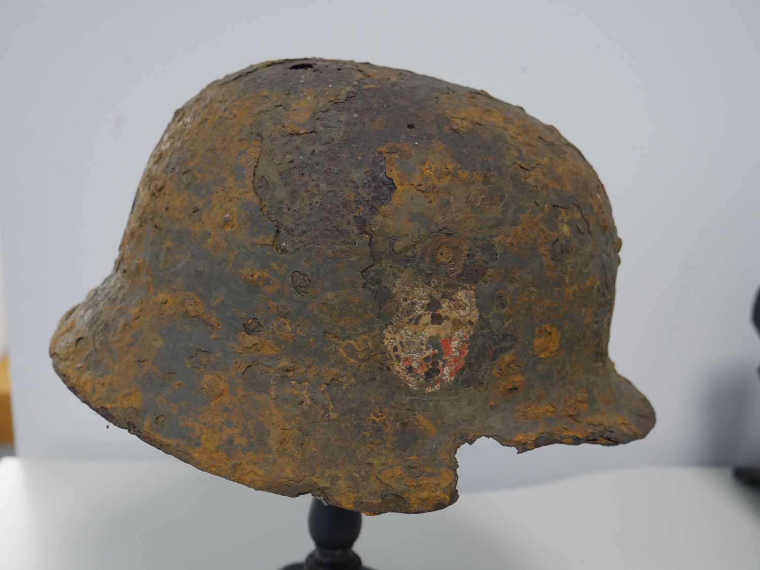 Military helmet bearing Nazi insignia on purpose built wooden stand Heavy rusting and deterioration - Image 5 of 6