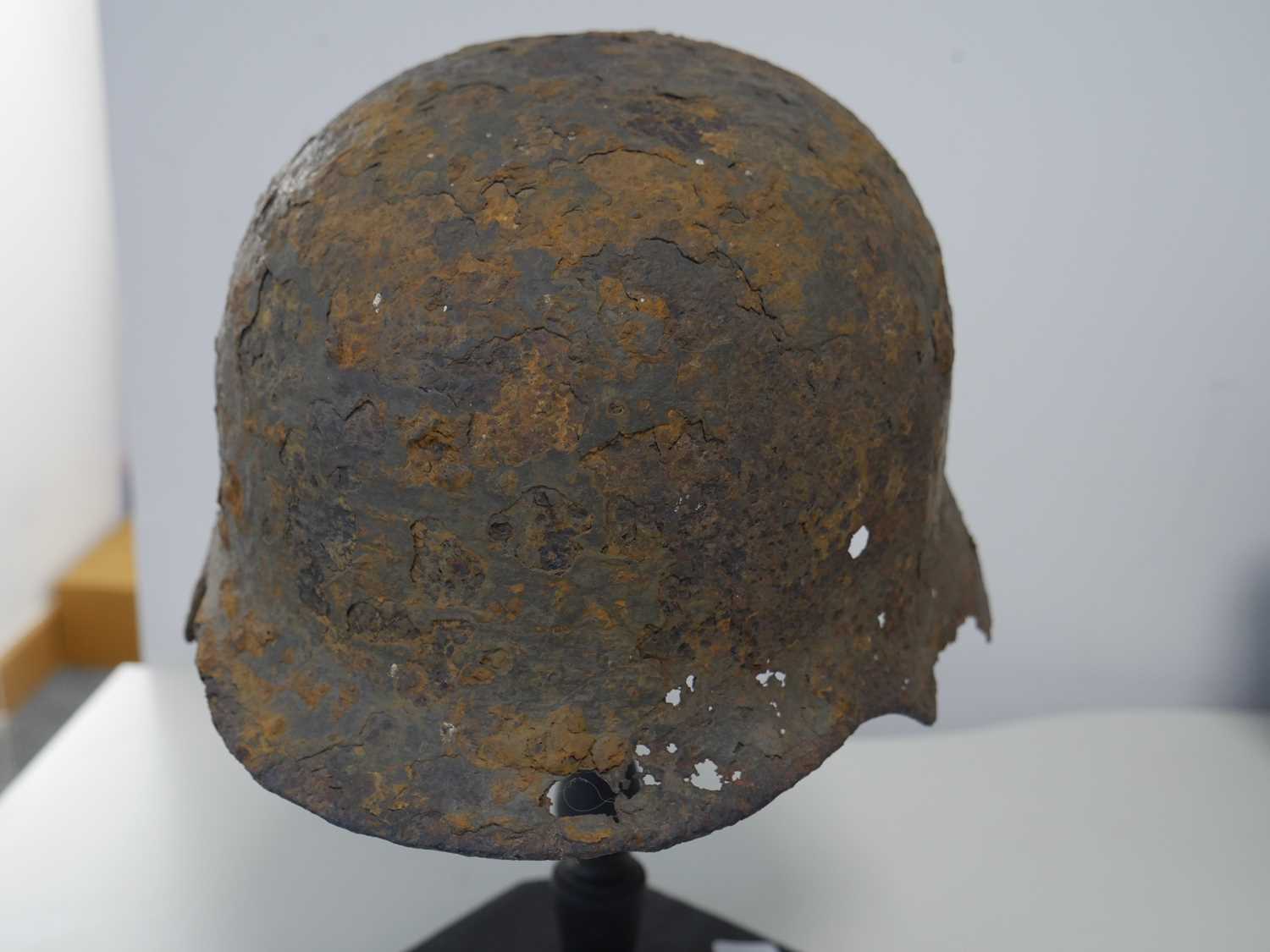 Military helmet bearing Nazi insignia on purpose built wooden stand Heavy rusting and deterioration - Image 6 of 6