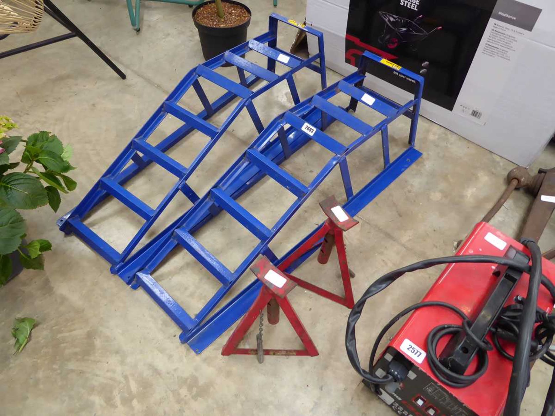 Pair of blue metal car ramps with 2 red metal axle stands