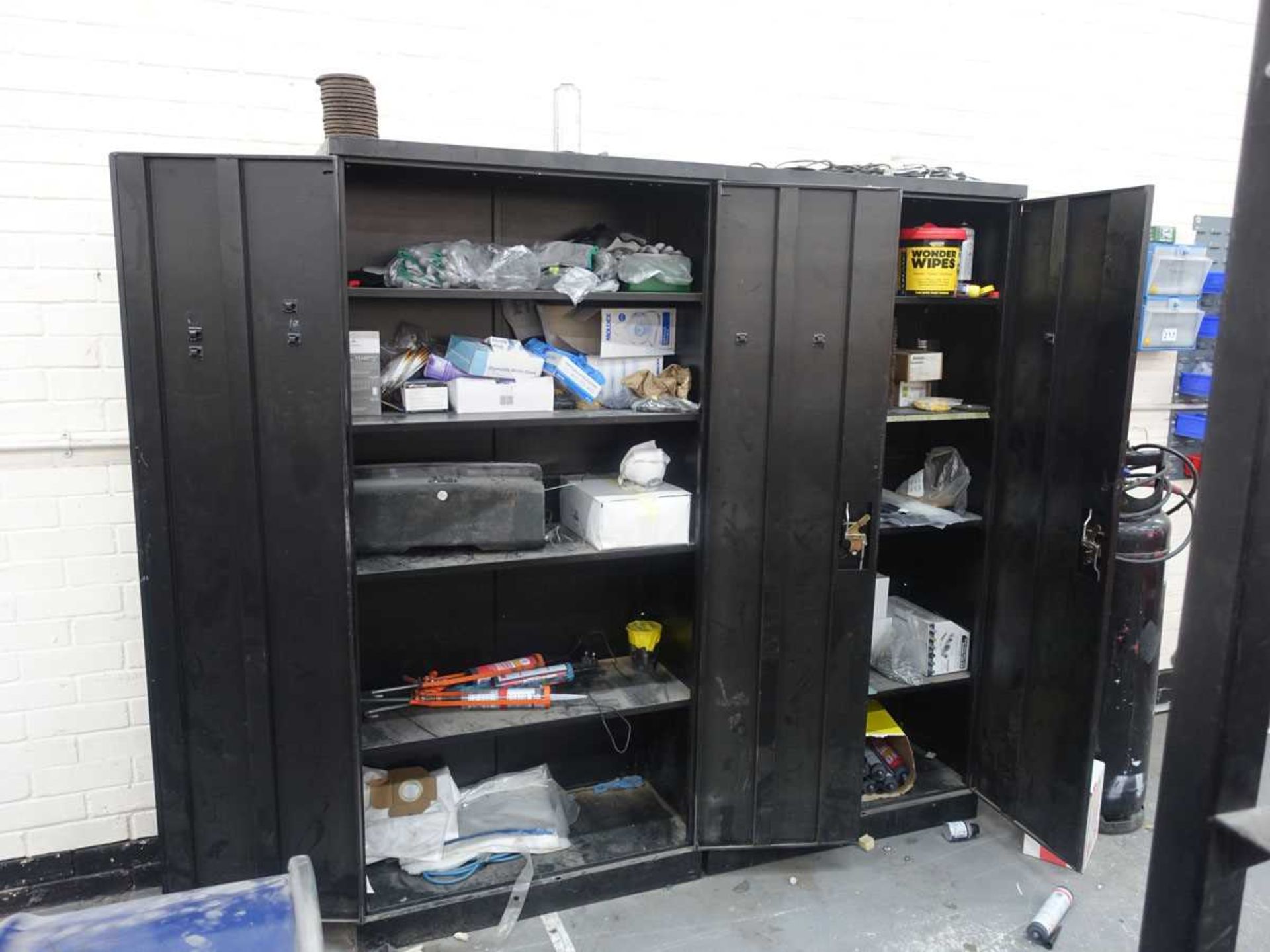 +VAT Two black steel double door cupboards with contents, together with linbin rack of nuts and