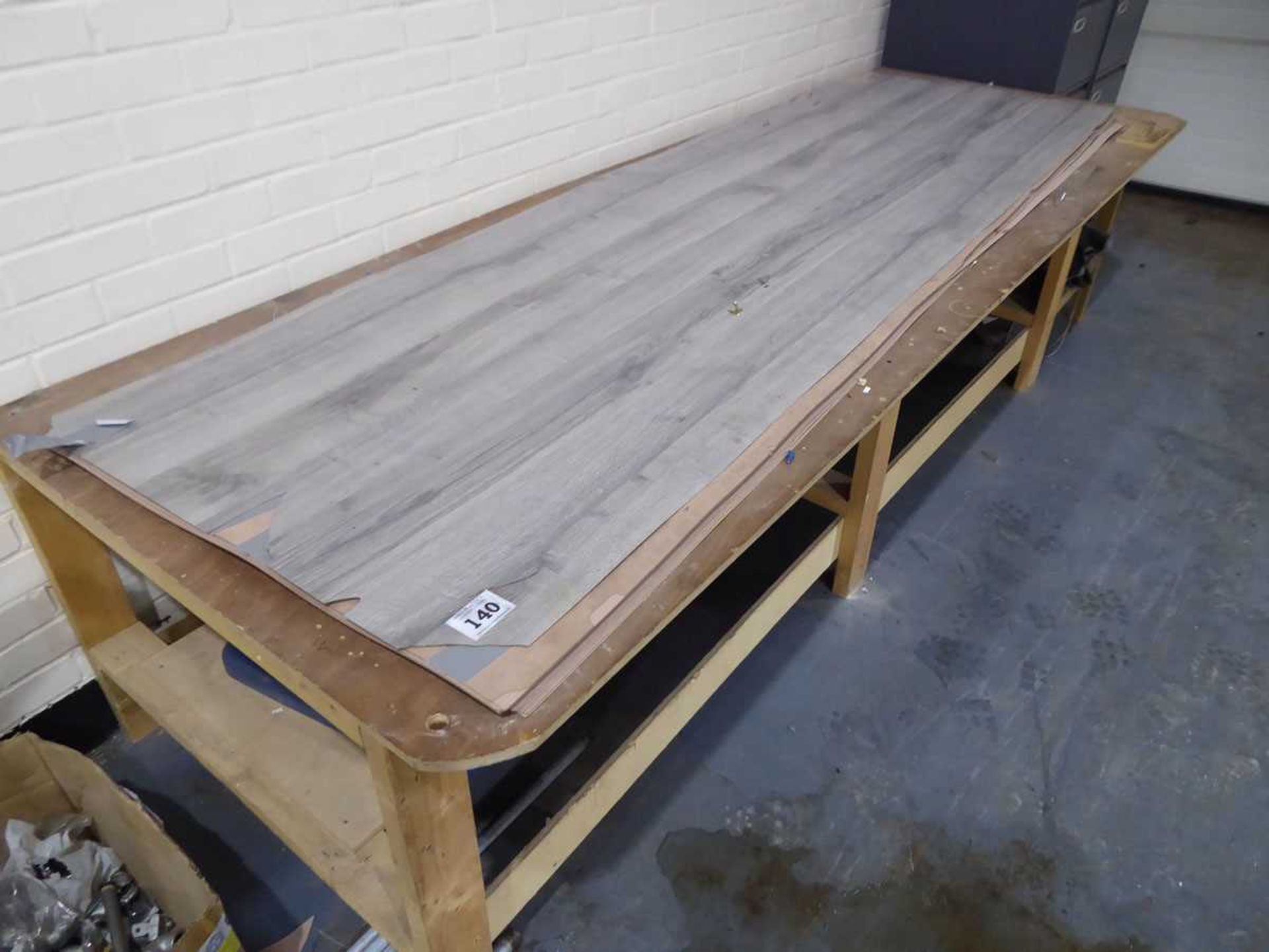 +VAT Quantity of grey wood grained Formica, together with a timber workbench