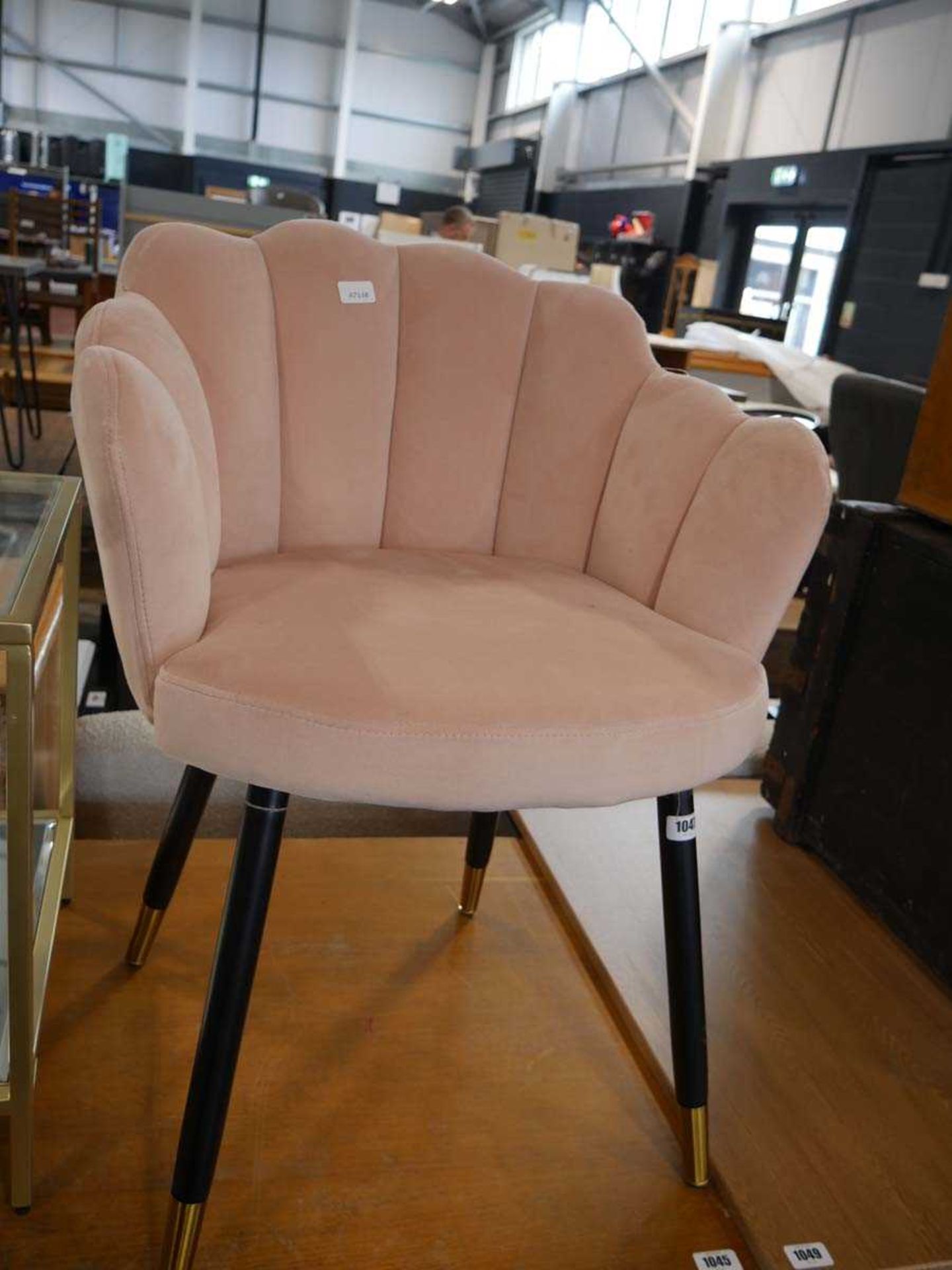 Pink suede upholstered shell shaped dining chair on black tapered supports