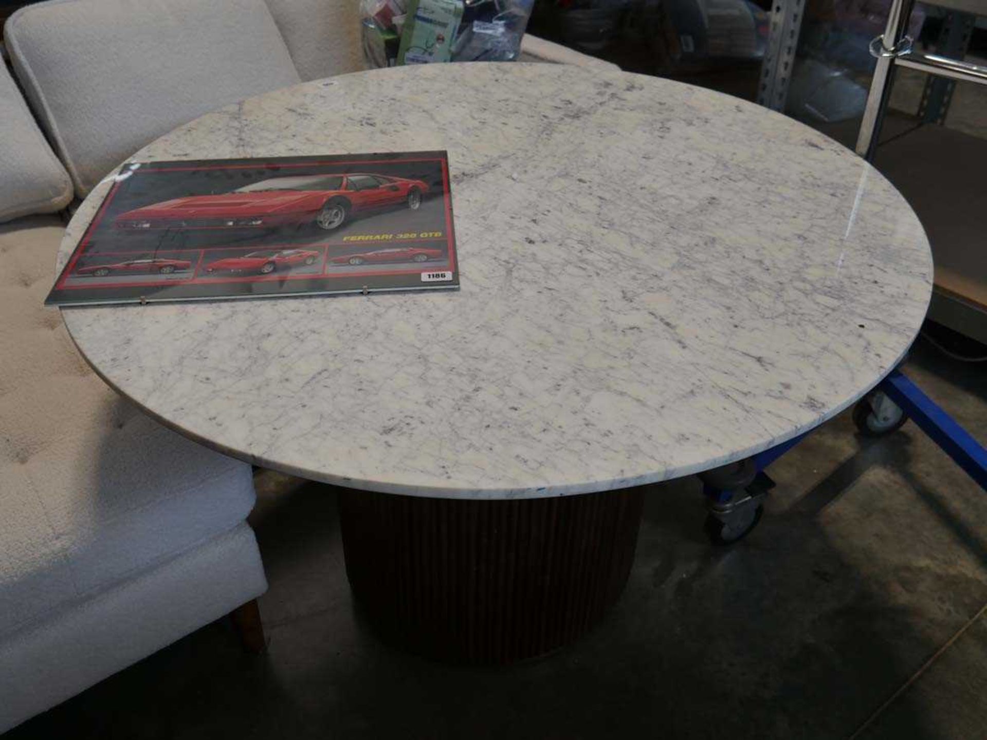 Circular dining table with marble effect surface and single pedestal ribbed wooden column shaped