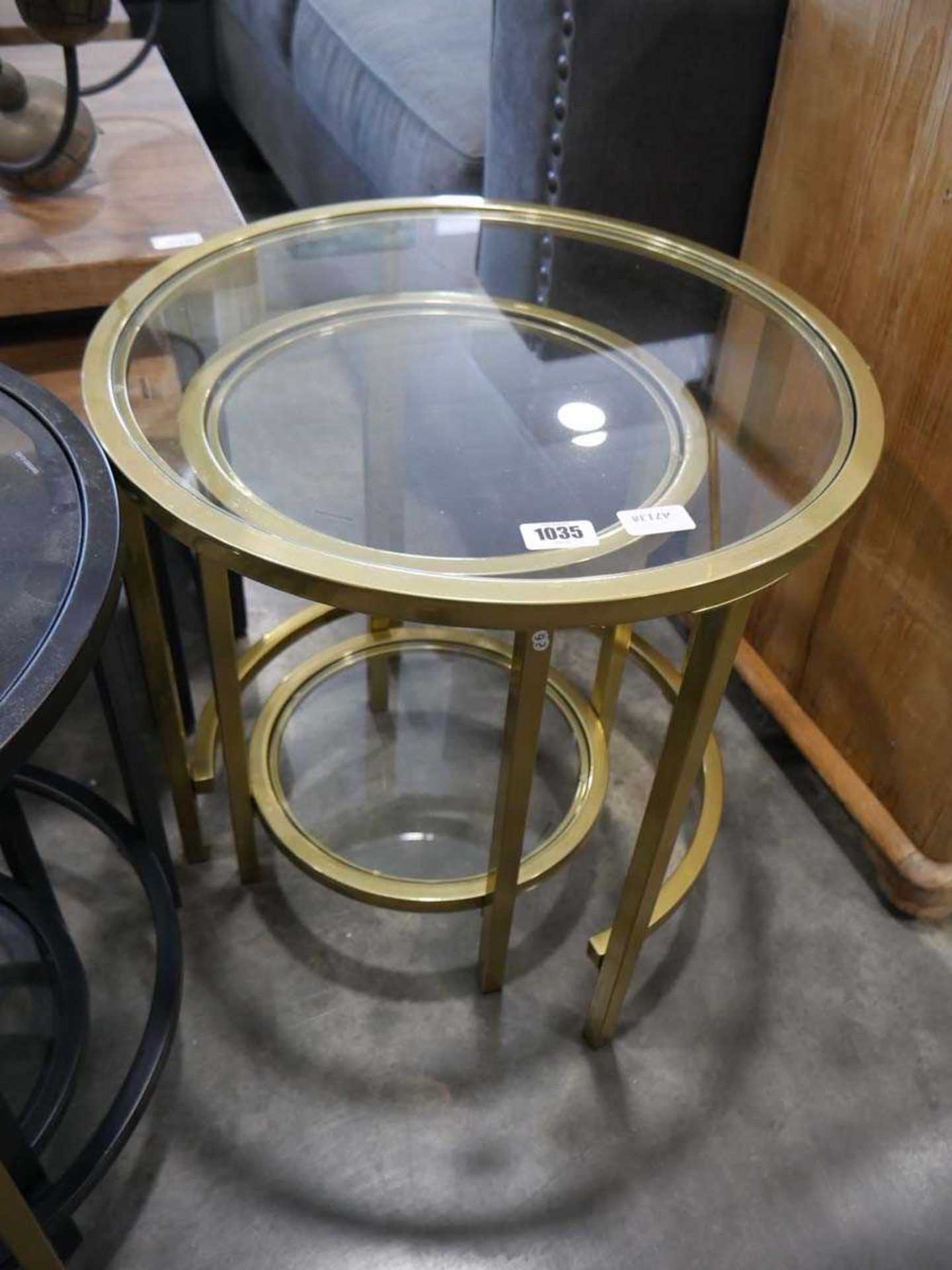 Nesting pair of brass effect framed circular occasional tables with glass surfaces