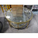 Nesting pair of glass top circular coffee tables in brass finish frames