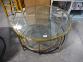 Nesting pair of glass top circular coffee tables in brass finish frames