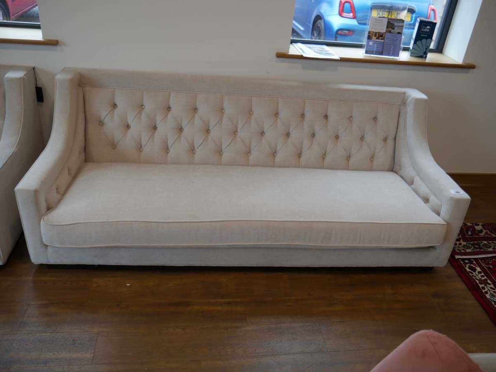 +VAT Low level beige upholstered button back sofa on black plinth type base