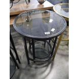 Nesting pair of black metal framed circular occasional tables with glass surfaces