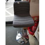 Grey upholstered bar stool on chrome support