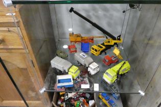 Shelf of play worn die cast vehicles incl. cranes, Dinky tipper truck, Dinky tanker, etc.