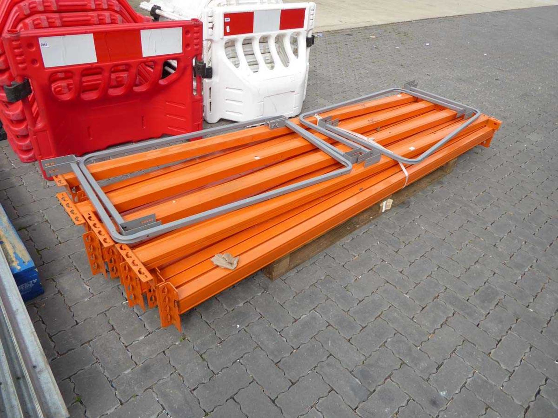 Pallet containing large quantity of orange metal racking cross beams