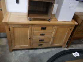 Modern light oak sideboard with 4 central drawers and 2 cupboards Some water damage to side Some