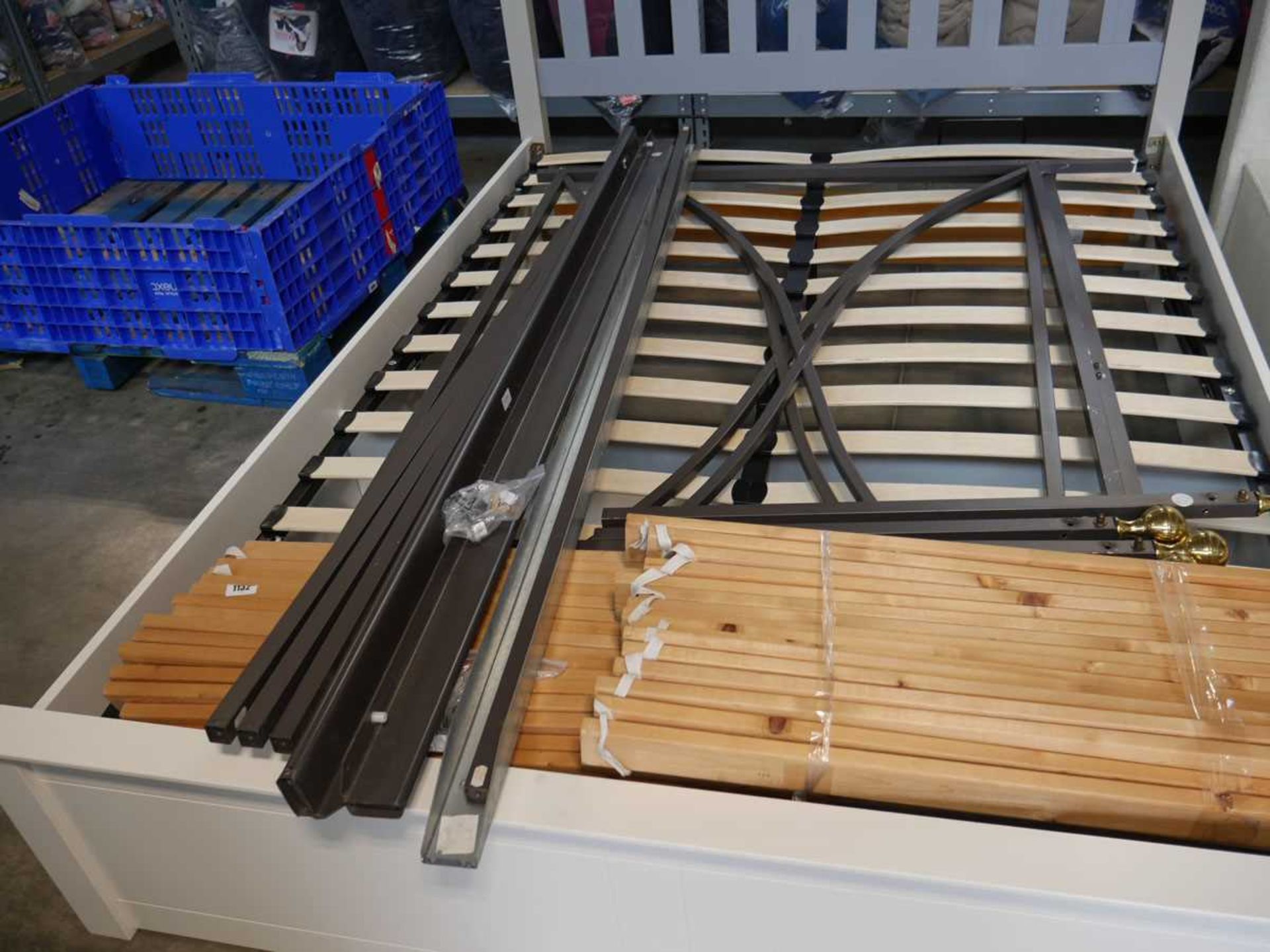 Unassembled metal double bed frame with wooden slats