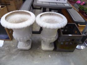 Pair of white plastic pedestal planters with weathered metal fire pit