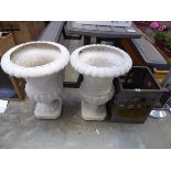 Pair of white plastic pedestal planters with weathered metal fire pit