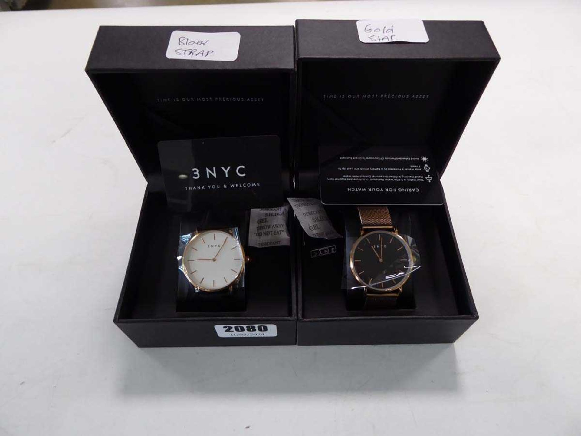2x 3 NYC wristwatches, 1 with black strap and white face and 1 with golden strap and black face
