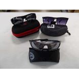 Three pairs of sunglasses in cases to include Emporio Armani, Ray Ban and Bear Grylls
