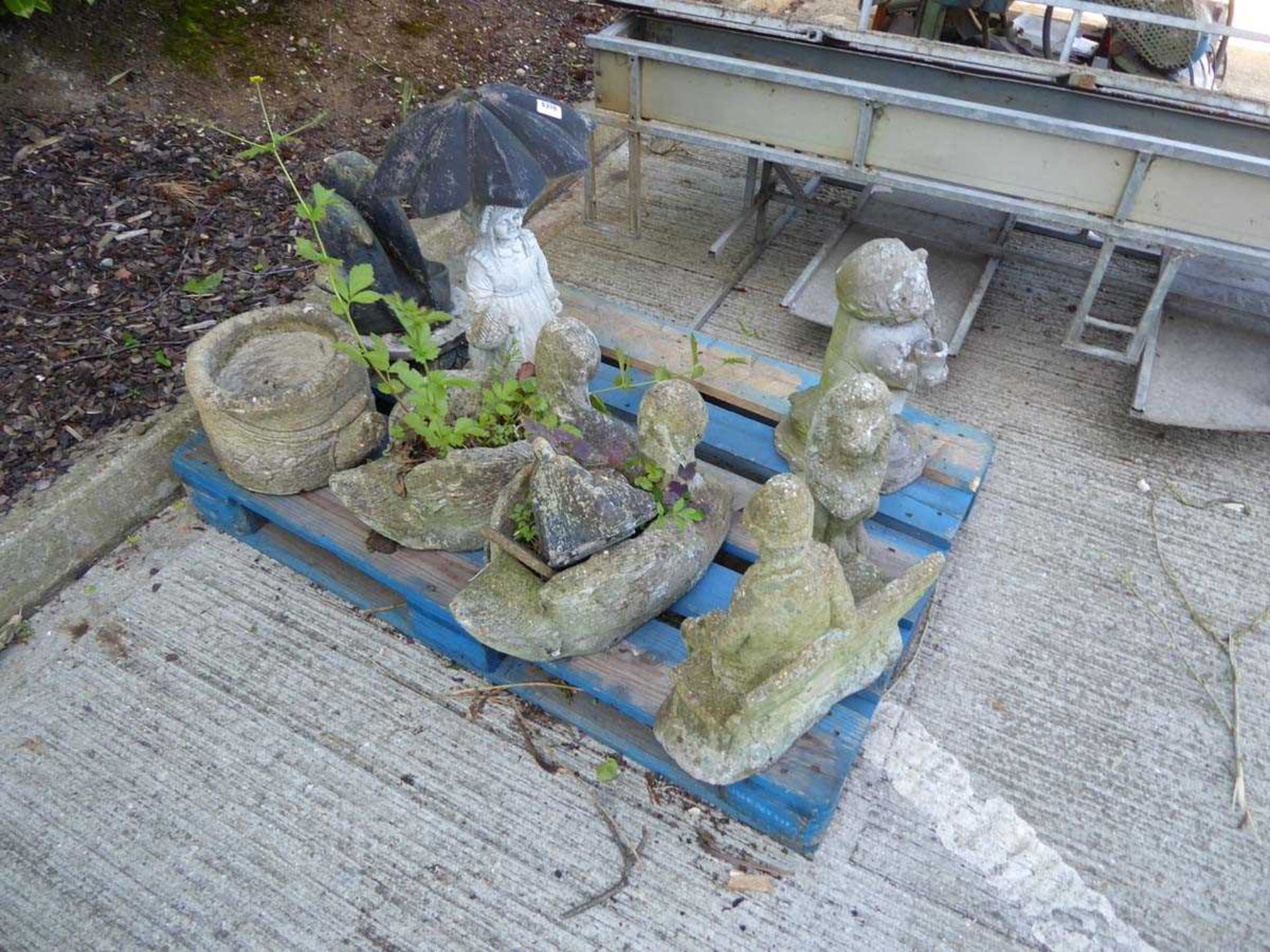 Pallet of concrete garden ornaments to include man on bench, swan, girl with umbrella etc