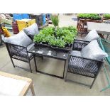 Rectangular glass topped metal framed table with four metal framed string chairs with cushions