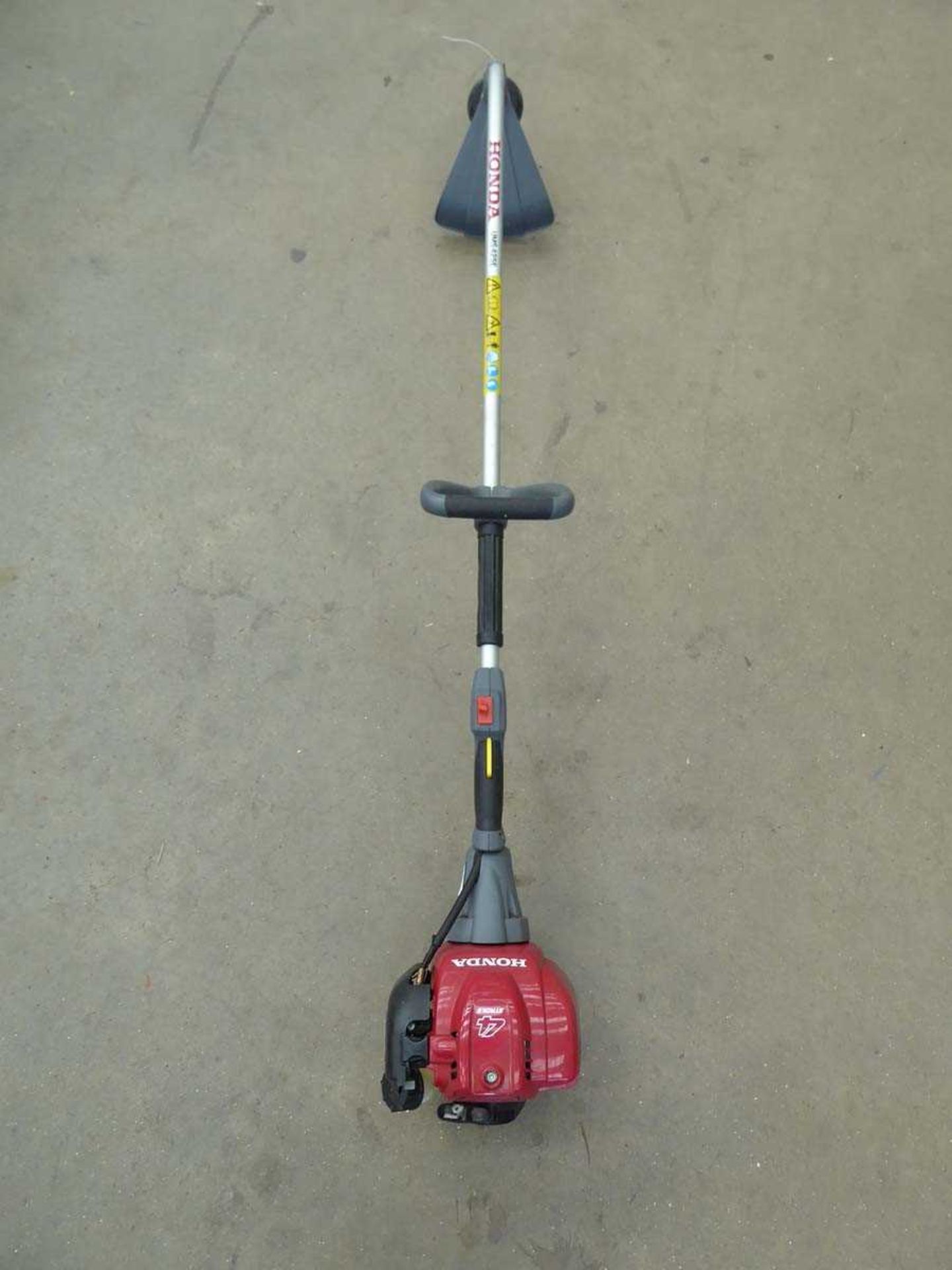 Red Honda petrol powered bent shaft strimmer