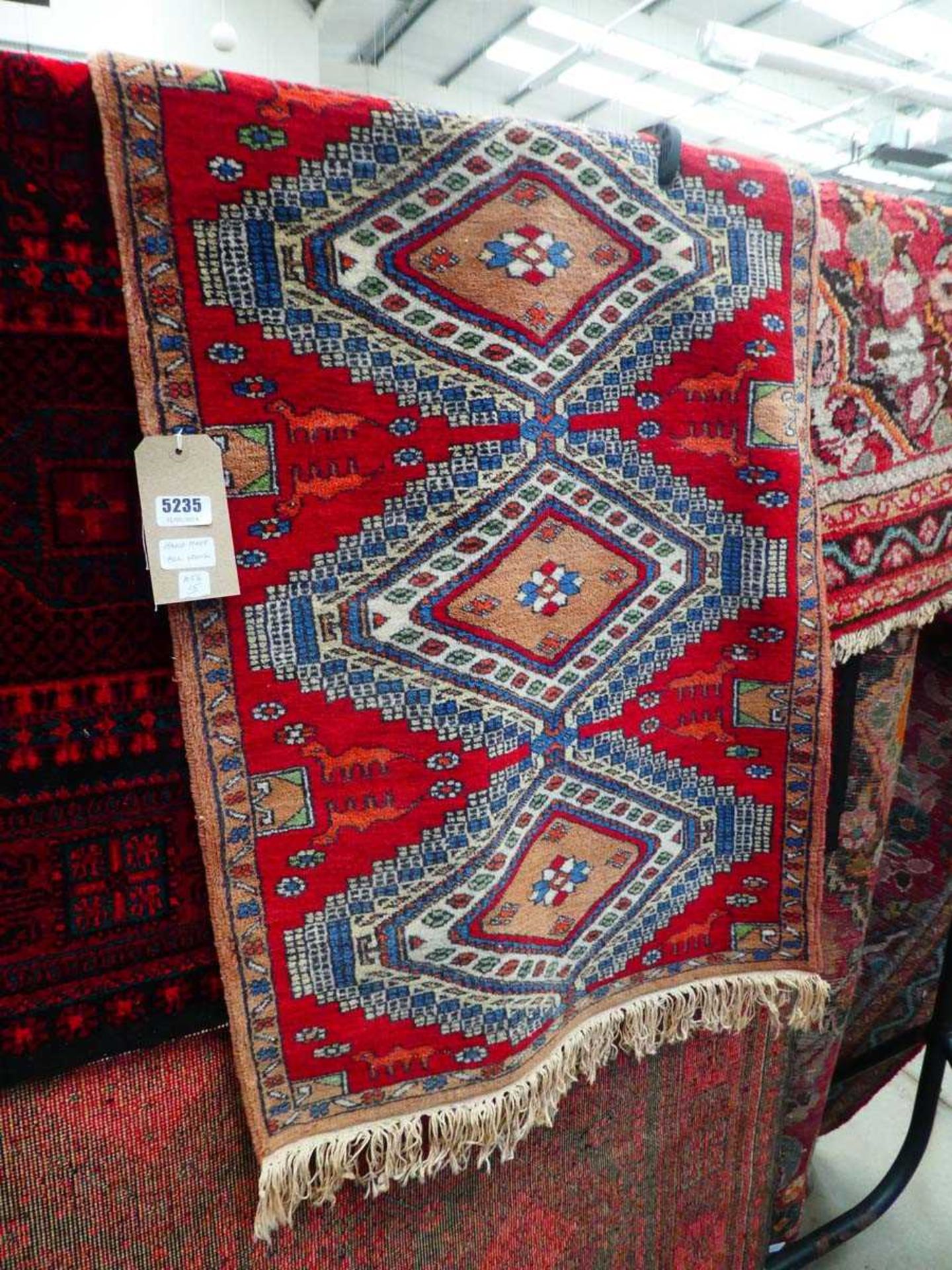 (15) Handmade woollen runner with red ground and repeated motifs